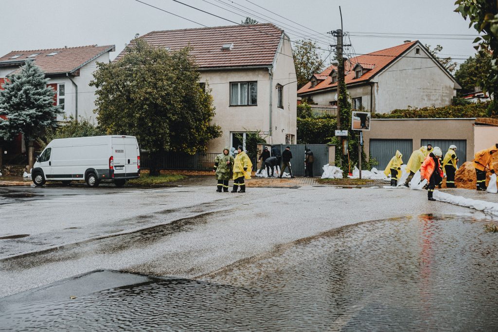 Emergency response team handling urban flooding with sandbags and protective gear