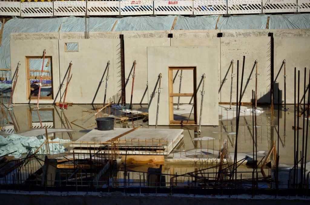 Flooded construction site with waterlogged ground and scattered materials, illustrating the wet conditions restoration techs work in